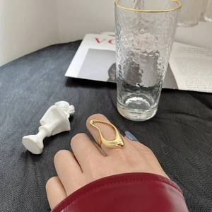 Irregular hollow gold ring in 925 sterling silver worn by model in a stylish artistic setting