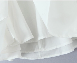 Detailansicht des weißen Minikleides mit Lagenlook-Saum und feiner Verarbeitungsqualität