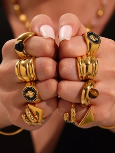 Detail of vintage gold rings with black gemstones and tiger eye stone in retro style
