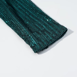 Detailed close-up of dark green sequins on the sleeve cuff with premium stitching