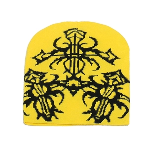 Dettaglio del berretto in maglia gialla con motivi jacquard gotici di farfalle