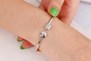 Detailed close-up of silver steel tree of life and Hope engraving on open bangle