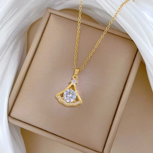 Gros plan du pendentif éventail doré serti de cristaux brillants dans son écrin à bijoux