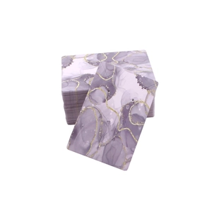 Macro detail of purple marble jewelry display cards with gold glitter accents and pre-cut holes