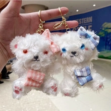 Close-up of cute bear plush keychains with pink and blue checkered bows and pockets