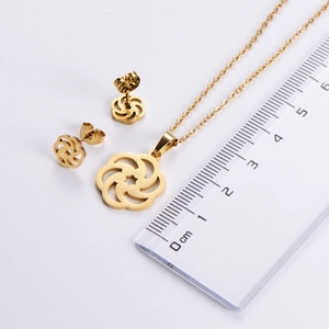 Close-up showing 2.2cm diameter of golden flower pendant and earring set next to a ruler