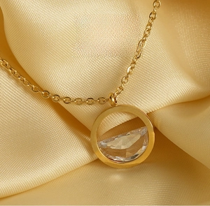 Detail of 18K gold-plated necklace with a floating zircon pendant on yellow silk
