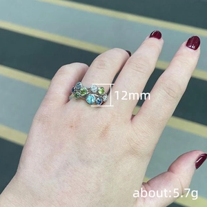 Silver ring with blue and green round gemstones worn on a hand, 12mm width, 5.7g
