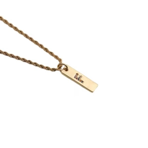 Close-up of golden twist chain necklace with a colorful zircon letter E pendant