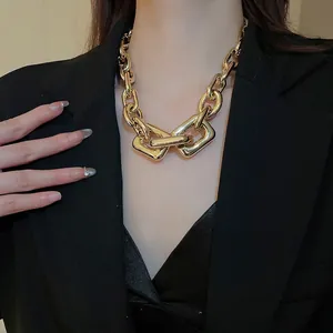 Chunky gold chain necklace with layered rectangle links on female model in black blazer