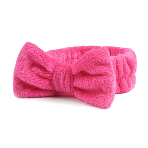 Detailopname van roze koraalvlies hoofdband met zachte pluche textuur en een strik