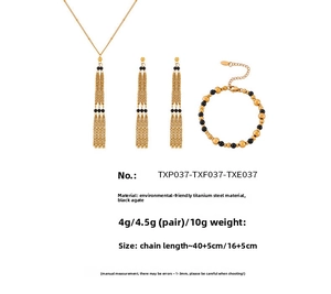 Detail view of gold titanium steel jewelry set featuring black agate beads and layered chains