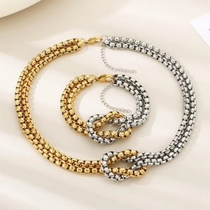 Detail view of two-tone gold and silver knotted square link necklace and bracelet set