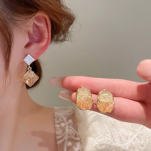 Detailed view of french vintage oval crystal earrings with golden edges and stone texture