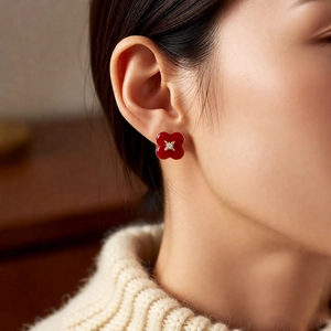 Close-up of vintage red enamel four-leaf clover earrings with sparkling center rhinestone