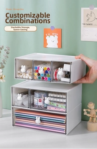 Close-up of modular white desk organizers with clear drawers and cute rabbit knobs
