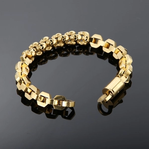 Detail shot of golden skull links and hexagonal elements on a heavy metal punk bracelet