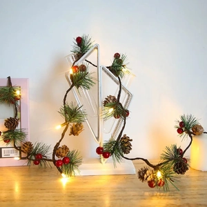 Christmas pine cone garland with LED lights, green needles, and red berries for decor