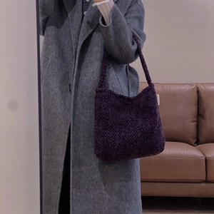 Dettaglio borsa a spalla in tweed viola intrecciata a mano con trama spessa su modella