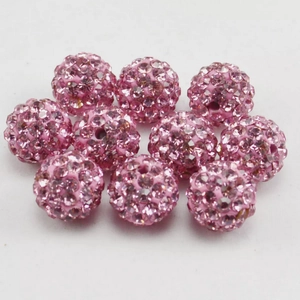 Makroaufnahme von 10 pinken 8mm Kristall-Lehmperlen mit komplettem Strassbesatz auf Weiß