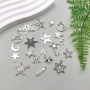 Close-up of antique silver star and moon pendants with Dream and Just For You engravings