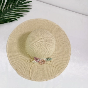 Beige wide brim straw sun hat with pink lace flowers for beach and sun protection