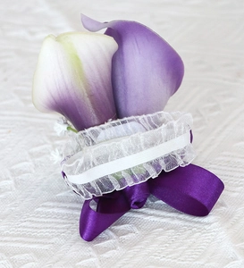 Detailed view of purple Calla Lily boutonniere with white lace trim and satin ribbon bow