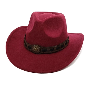Detail of burgundy wool cowboy hat featuring a leather band and bronze star emblem