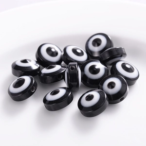 Detailed view of black and white resin evil eye flat round spacer beads for jewelry DIY