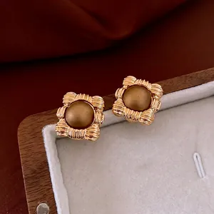 Vintage goldene quadratische Ohrstecker mit Streifenstruktur in einer Schmuckschatulle