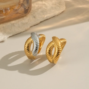 Detailed view of textured cross rings with 18k gold plating and ribbed metal patterns