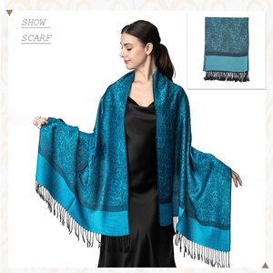 Detailed close-up of blue paisley jacquard fabric with elegant tassel fringes