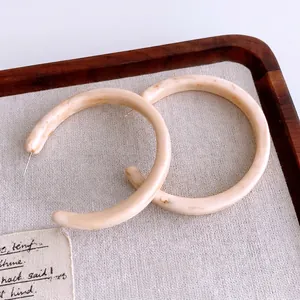 Retro C-shaped resin hoop earrings in cream marble texture with silver pins