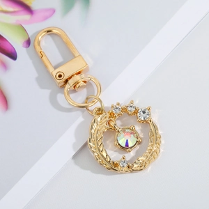 Detailed view of a gold keychain with sparkling rhinestones and leaf texture
