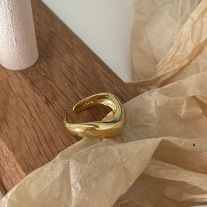 Minimalist S925 sterling silver curved ring in gold finish on a wooden background