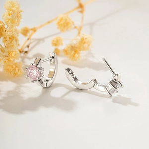 Orecchini a cerchio in argento con zirconi rosa rotondi e pietre bianche su fondo bianco