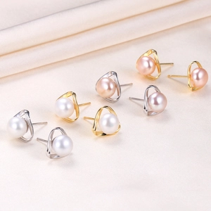 Macro detail of natural freshwater pearl earrings with hollow triangle geometric design
