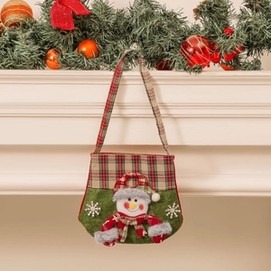 Christmas snowman gift bag with red plaid handle and green felt fabric hanging on fireplace