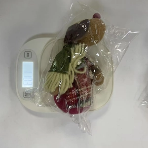 Detailed view of plush reindeer Christmas ornament showing 110.3g weight on a scale