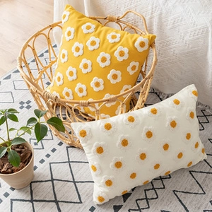 Detail of yellow and beige tufted floral cushions in a cozy rustic home setting