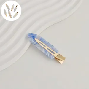 Close-up of a 7cm blue marble acetate hair clip with a sturdy gold metal spring