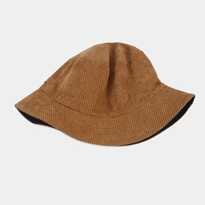 Detail of corduroy texture and stitching on a reversible bucket hat in caramel color