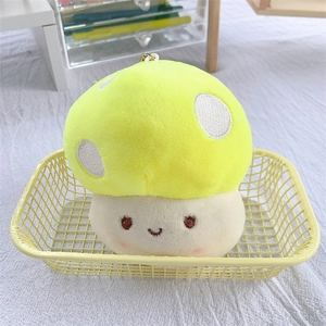 Cute plush mushroom keychain with yellow cap and smiling face in a yellow basket