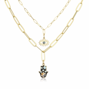 Detail of 18K gold-plated layered necklace with Hamsa hand and blue evil eye charms
