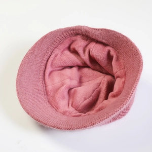Close-up of pink knitted winter hat showing thick warm fleece lining and soft texture