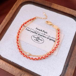 Detail of 18k gold plated double-layer bracelet with red rope and sparkling zircon