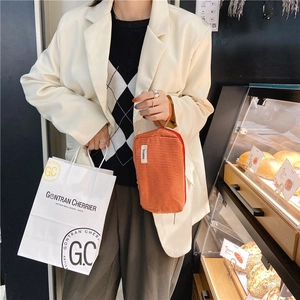 Vue détaillée d'une trousse à maquillage élégante en toile à carreaux orange avec anse
