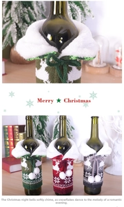Detail view of knitted Christmas wine bottle covers with reindeer patterns and faux fur trim