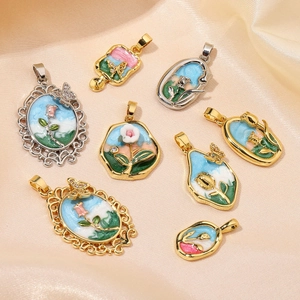 Collection of 18k gold floral enamel pendants on beige silk fabric background