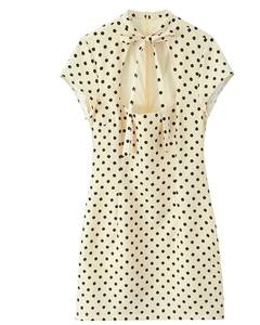 Detail of polka dot dress featuring a heart-shaped cutout back and bow tie collar
